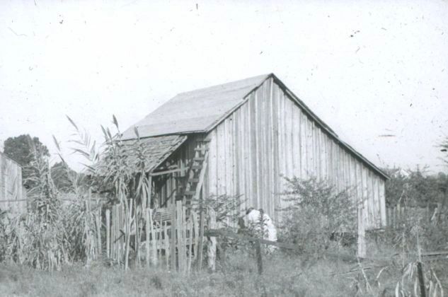 A black and white photo of an old barn.