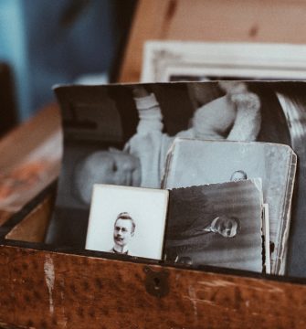 A wooden box with old photos of a baby.