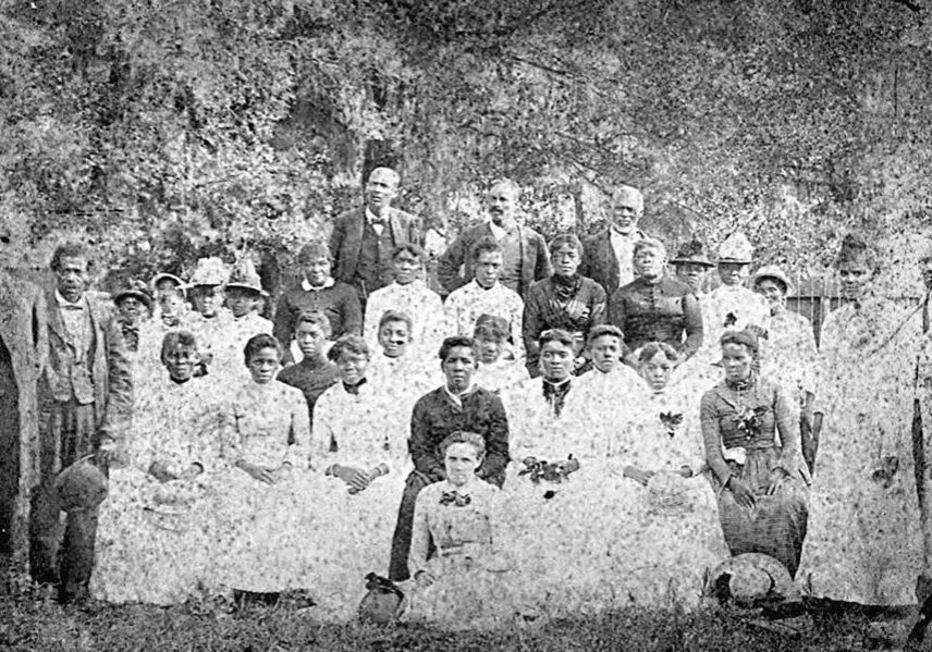 A group of people in white clothes and hats.
