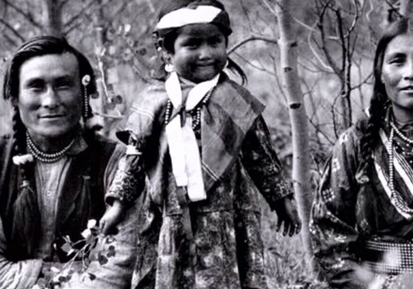 A young girl in native dress with two men.